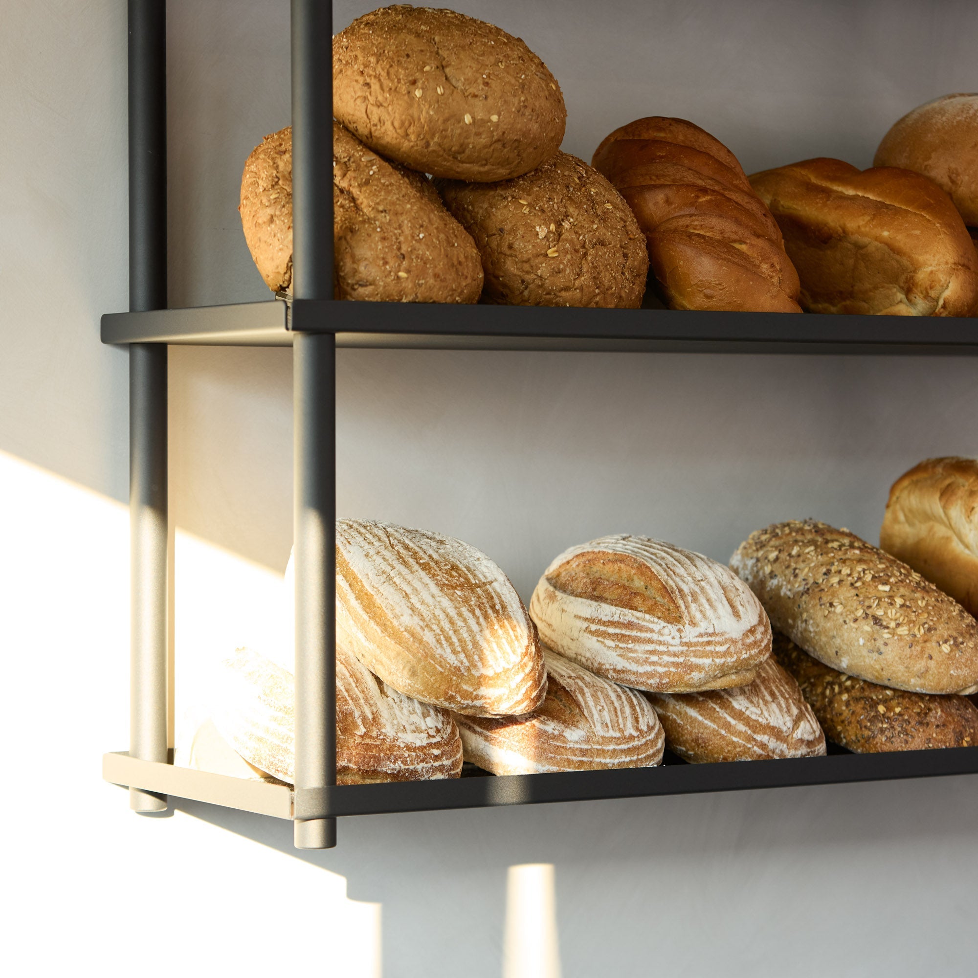 closer up of black ceiling mounted shelves displaying bread at a bakery