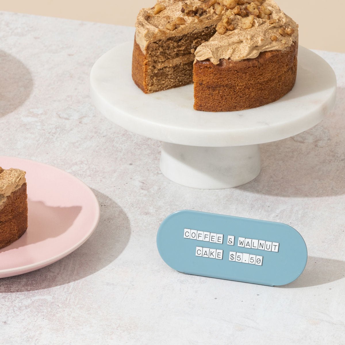 blue curve counter pricing display sign in front of a carrot cake