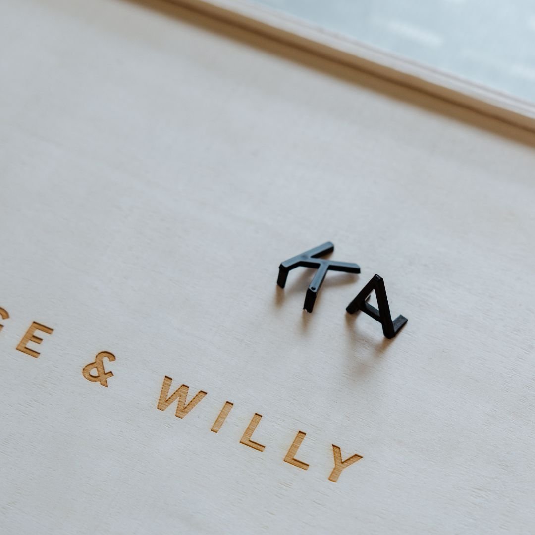 two felt letters on top of the storage box beside george & willy logo