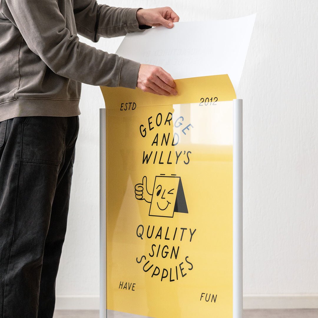 person inserting acrylic panels into a white poster sidewalk pavement sign