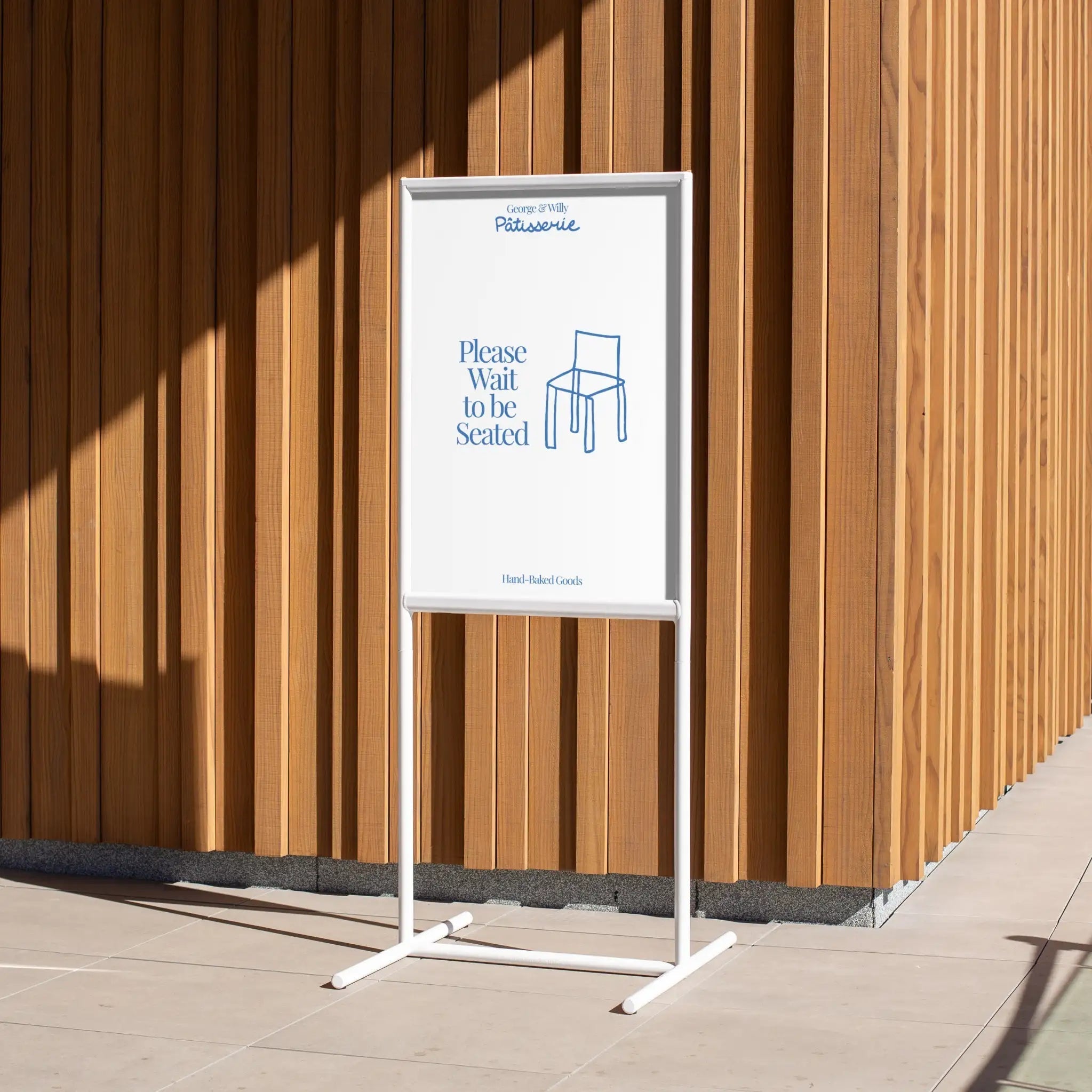tall white poster sidewalk shop sign against a wooden wall