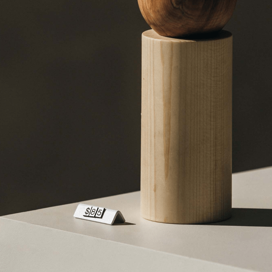 white pricing tag in front of a wooden product showing price