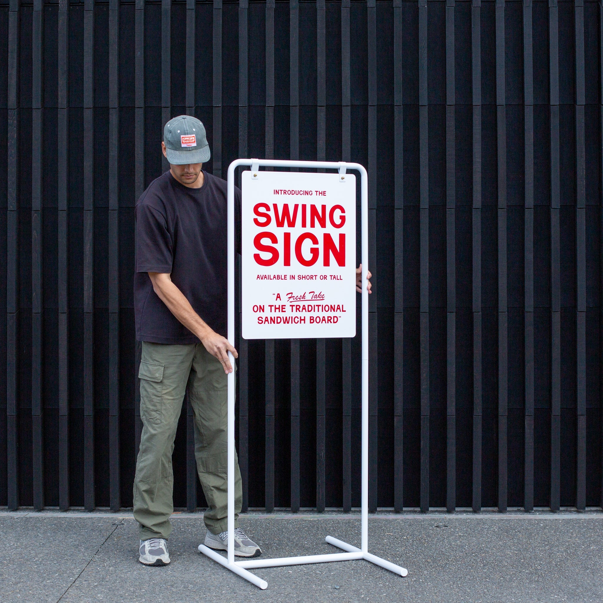 person adjusting the tall version of the swing sandwich board sign using extension rods