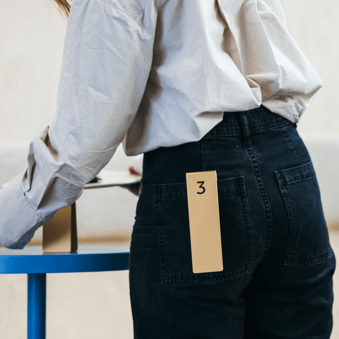 Server carrying food past table with aluminum number stacker showing table number three