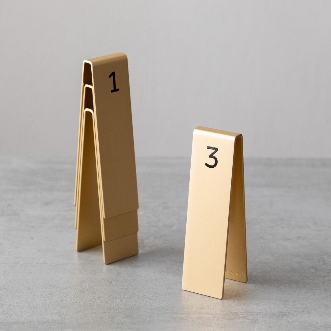 Set of aluminum table number flags stacked in gold finish with numbers 1 and 3 displayed