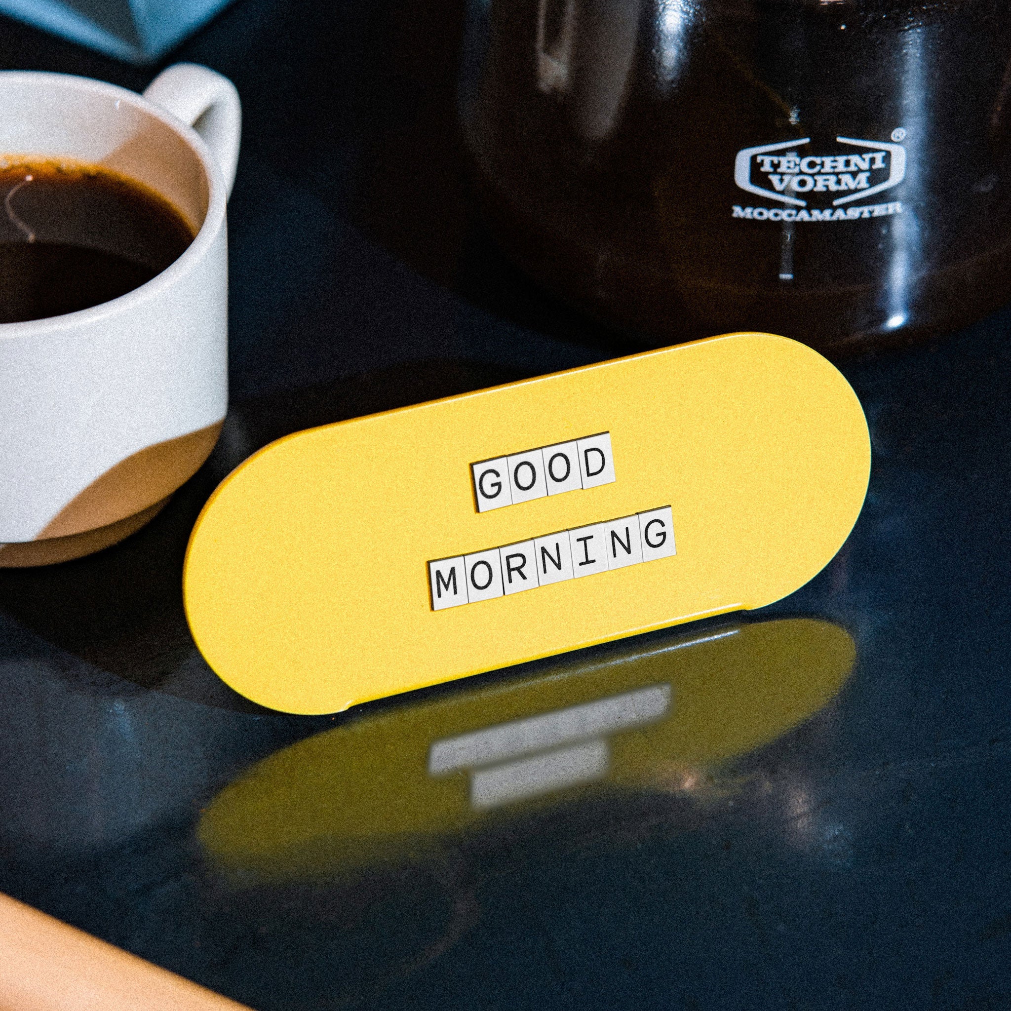 yellow curve counter sign in front of a cup of coffee