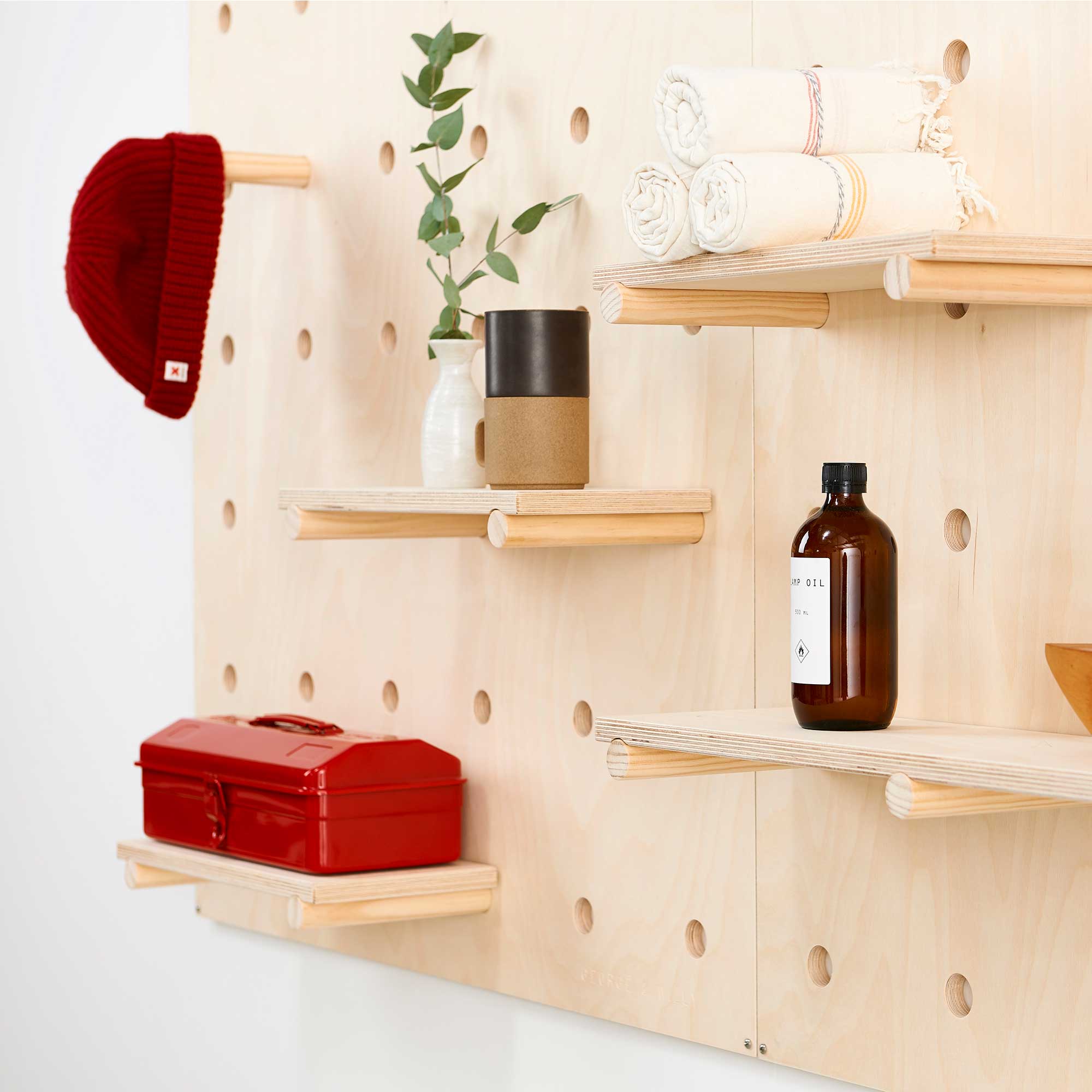 george & willy pegboard shelf board with extra shelves and pegs holding various items