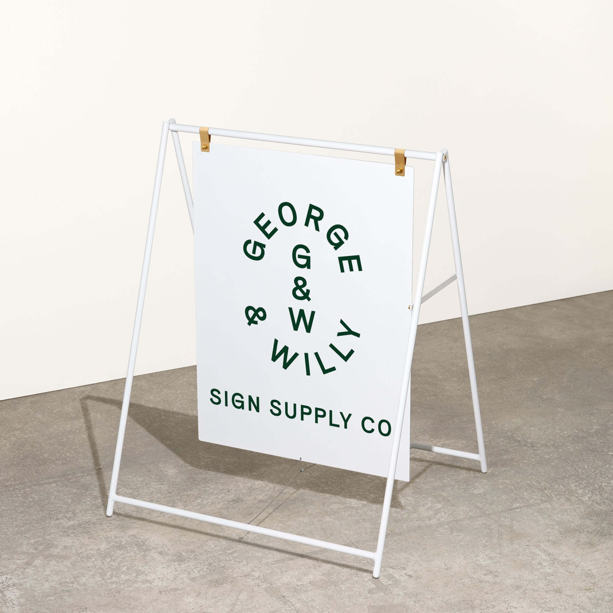 white large sidewalk sign with george & willy logo applied inside a studio