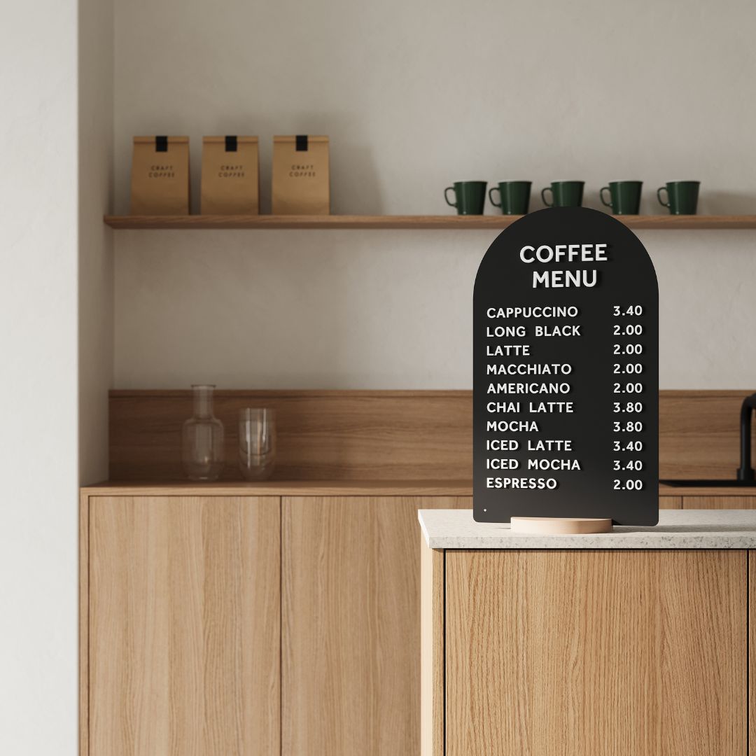 black arch tabletop sign on a wooden countertop