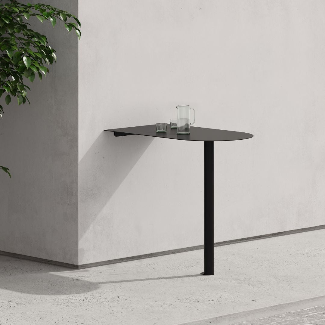 Minimal black aluminum booth table mounted to wall in slim profile