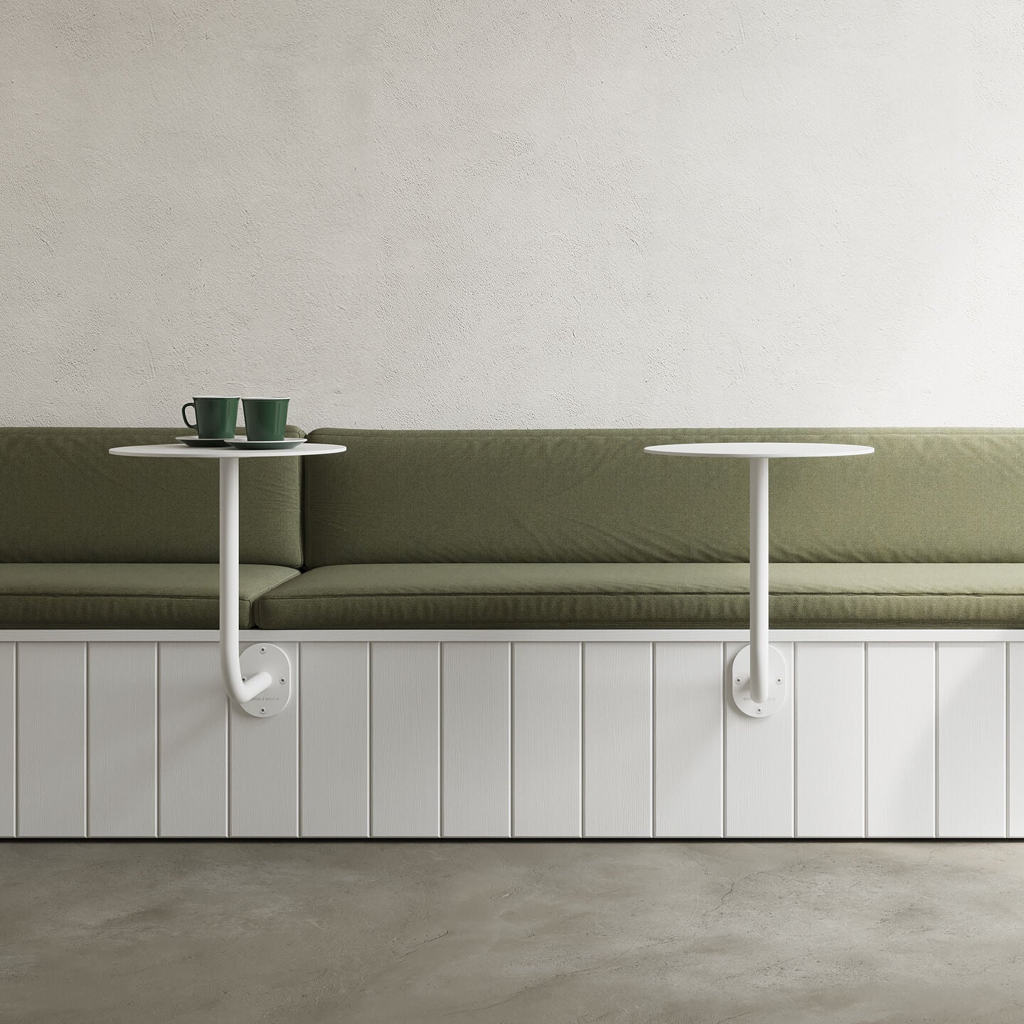 Two coffee shop wall mounted cafe tables attached to white booth seat with green squabs