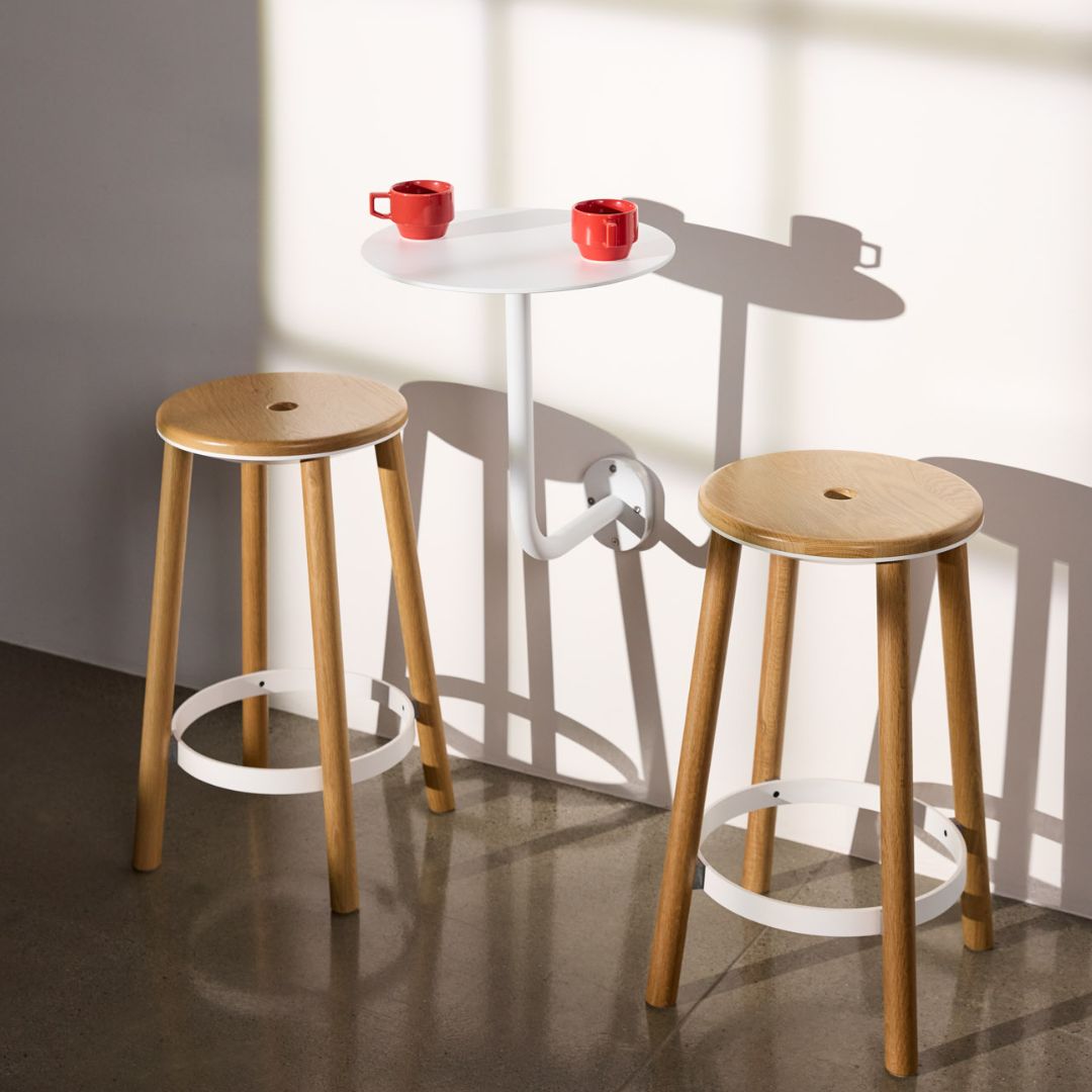 White cafe table with bar stools and red cofee mugs showing height as a restaurant table