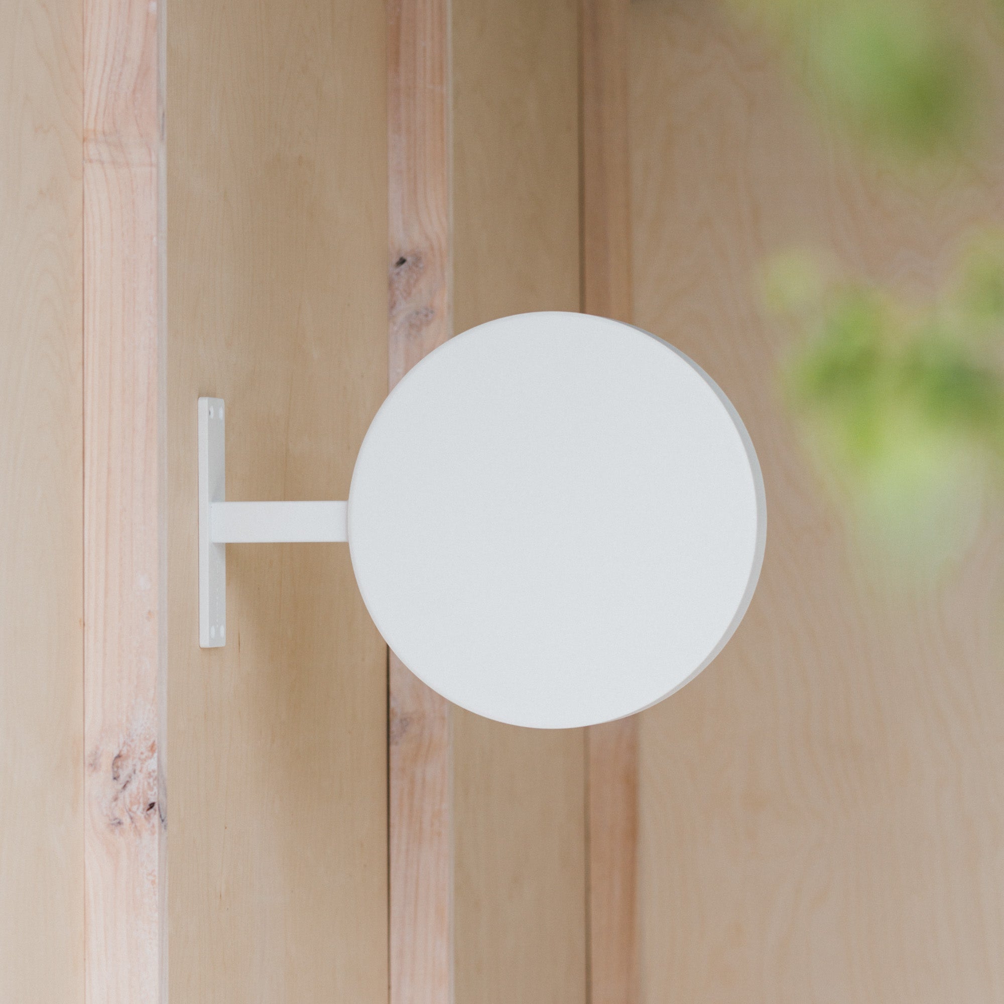 plain white round sign mounted on a wooden beam