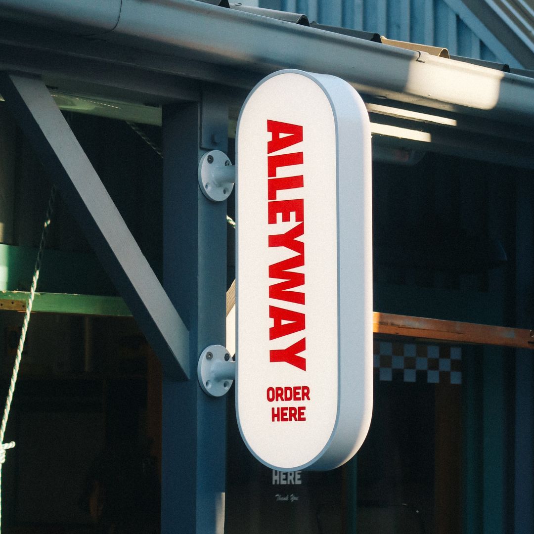 close up of the white curve lightbox LED sign installed on a wooden beam with red logo branding applied