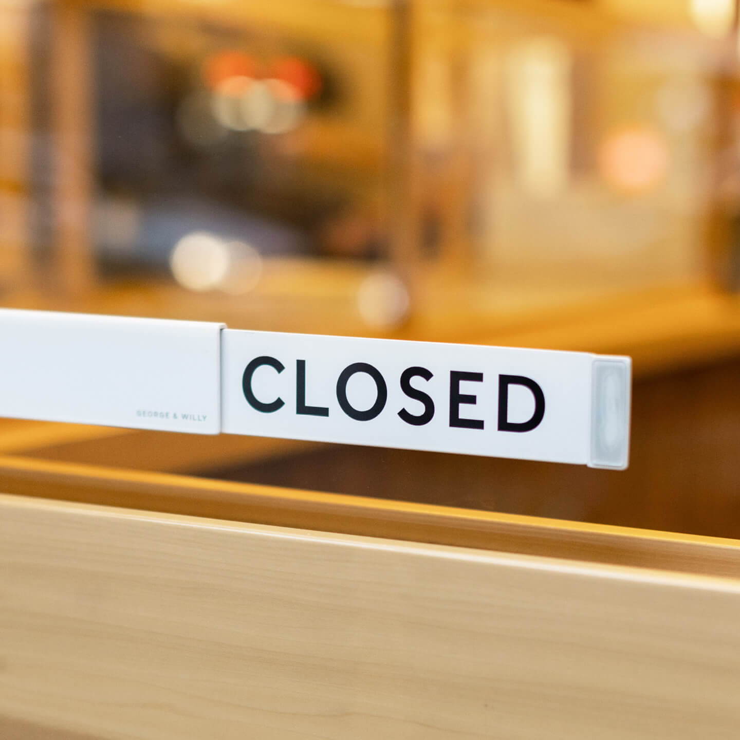 Aluminum Open Closed sign on glass cafe window showing CLOSED