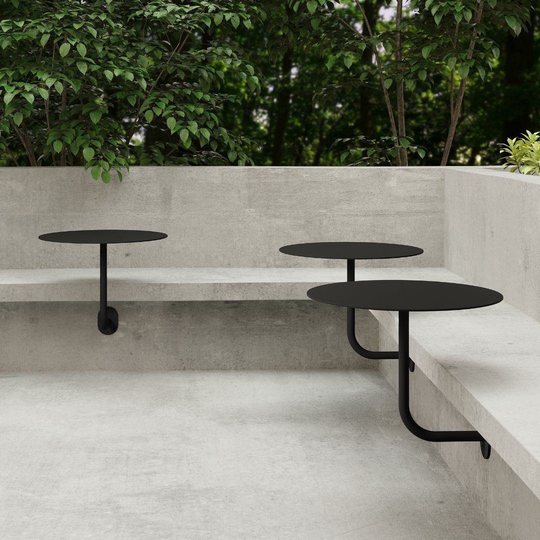3x black wall-mounted cafe tables setup outdoors along outdoor cafe seating, showcasing space-saving restaurant table design