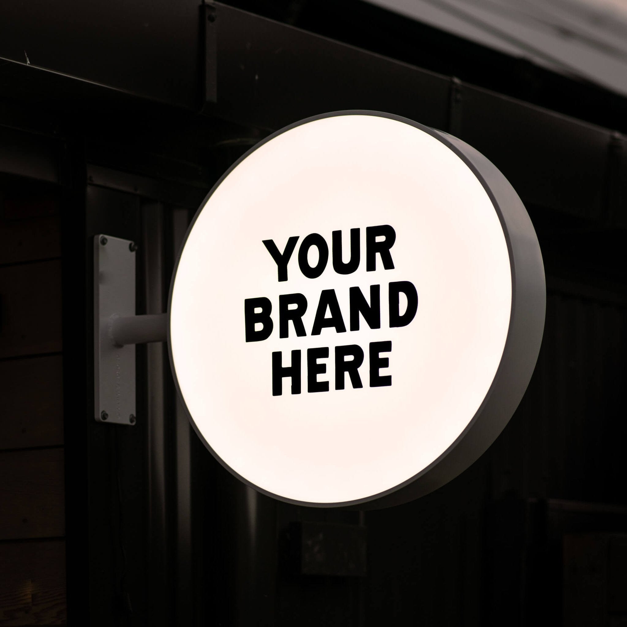 lit up round light box sign with "your brand here" displayed on the panel for an example logo