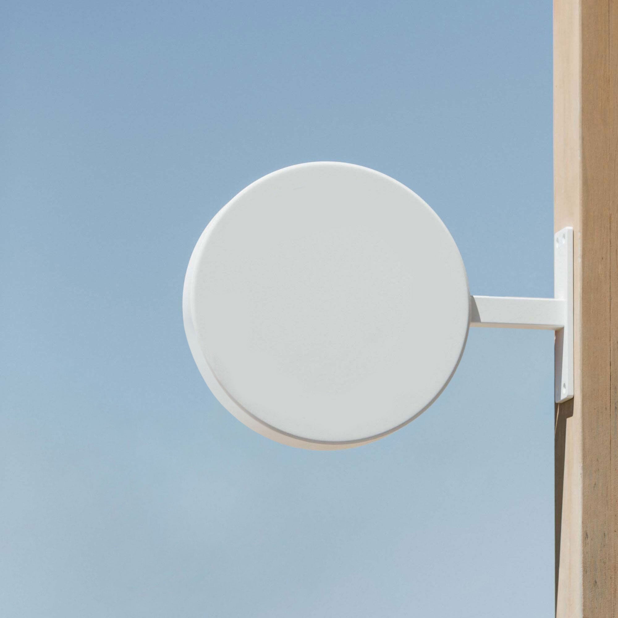 plain white round sign mounted on a wooden beam