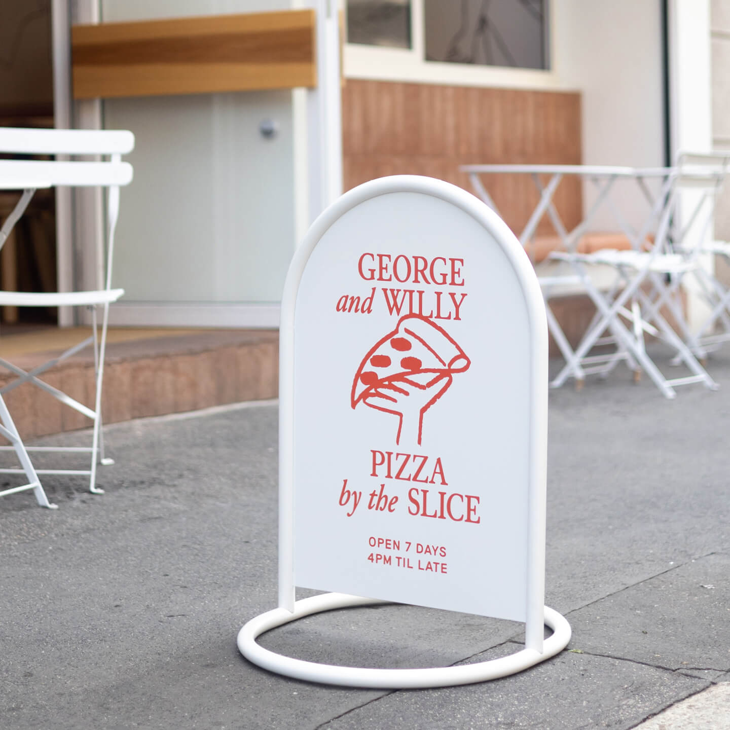 white rounded sidewalk metal sign in front of outdoor tables on a sidewalk