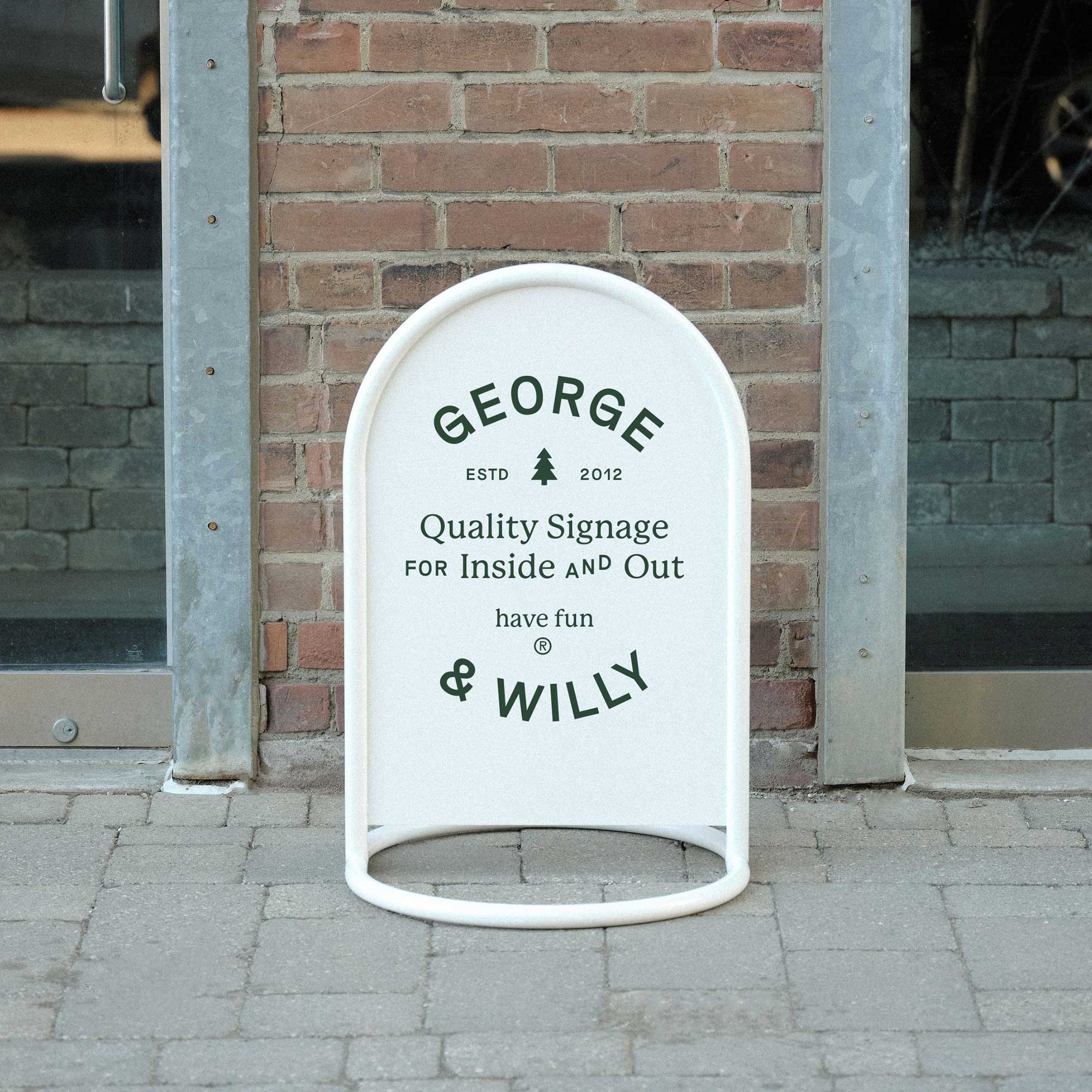 white rounded sidewalk metal signage on a sidewalk outside brick facade