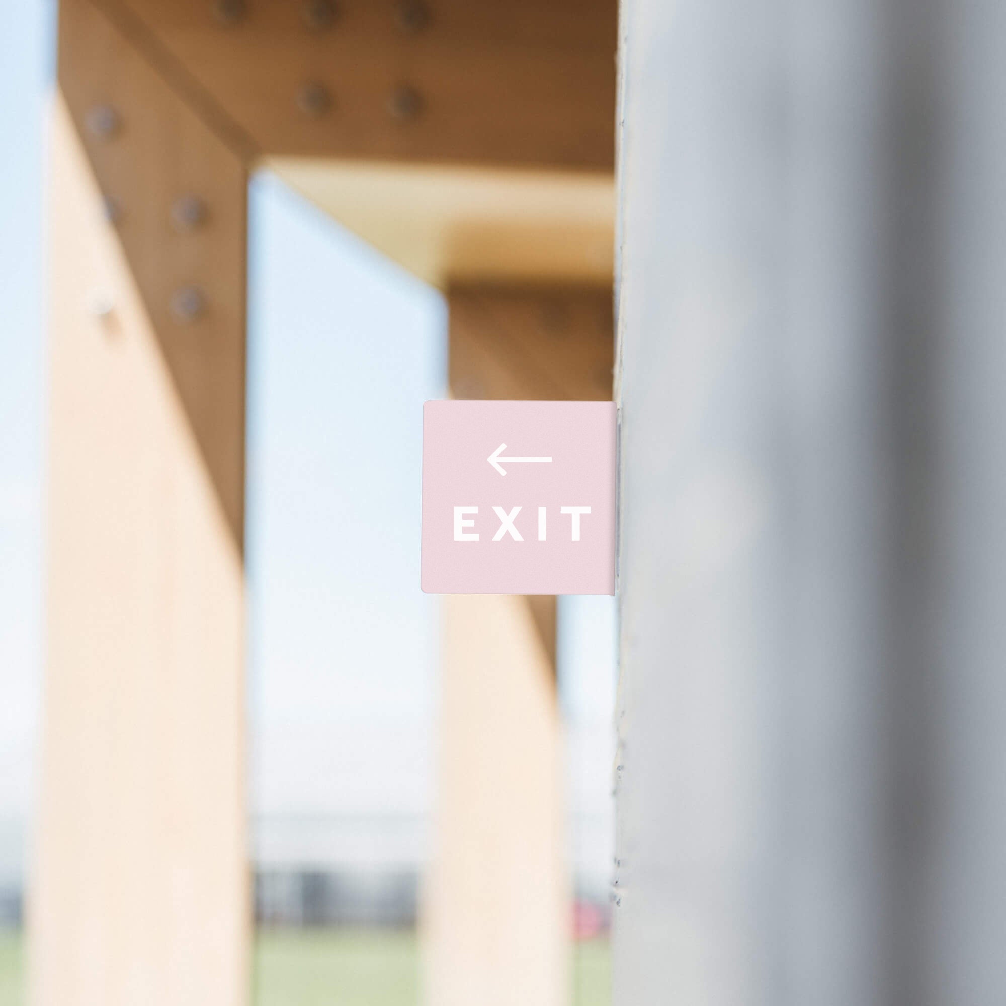 pink square blade sign with exit sign decals on it