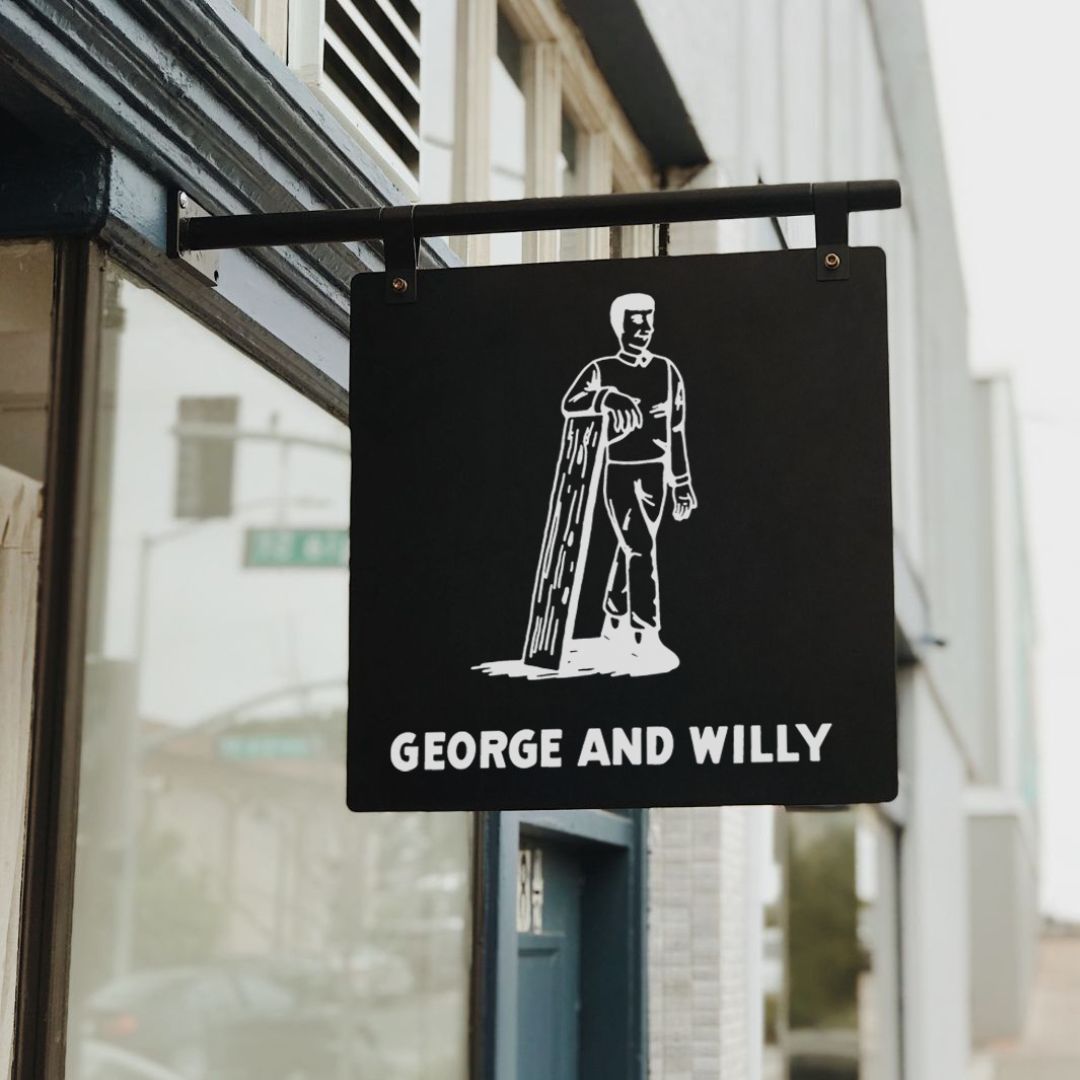 black metal hanging wall storefront sign with company branding applied