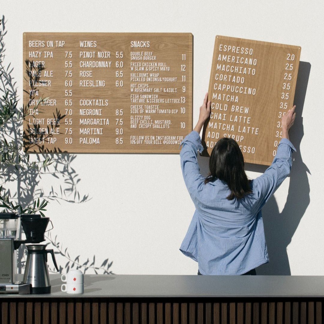girl hanging up the wooden peg letter board on the wall