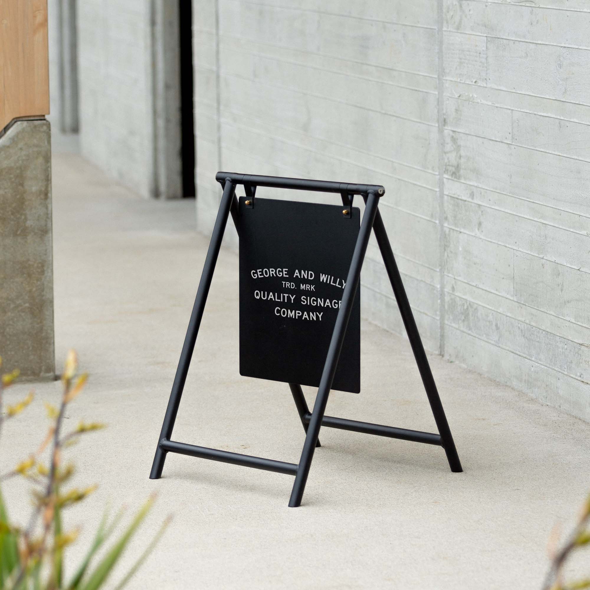 A black metal A-Frame freestanding sign for advertising a business on the street or sidewalk