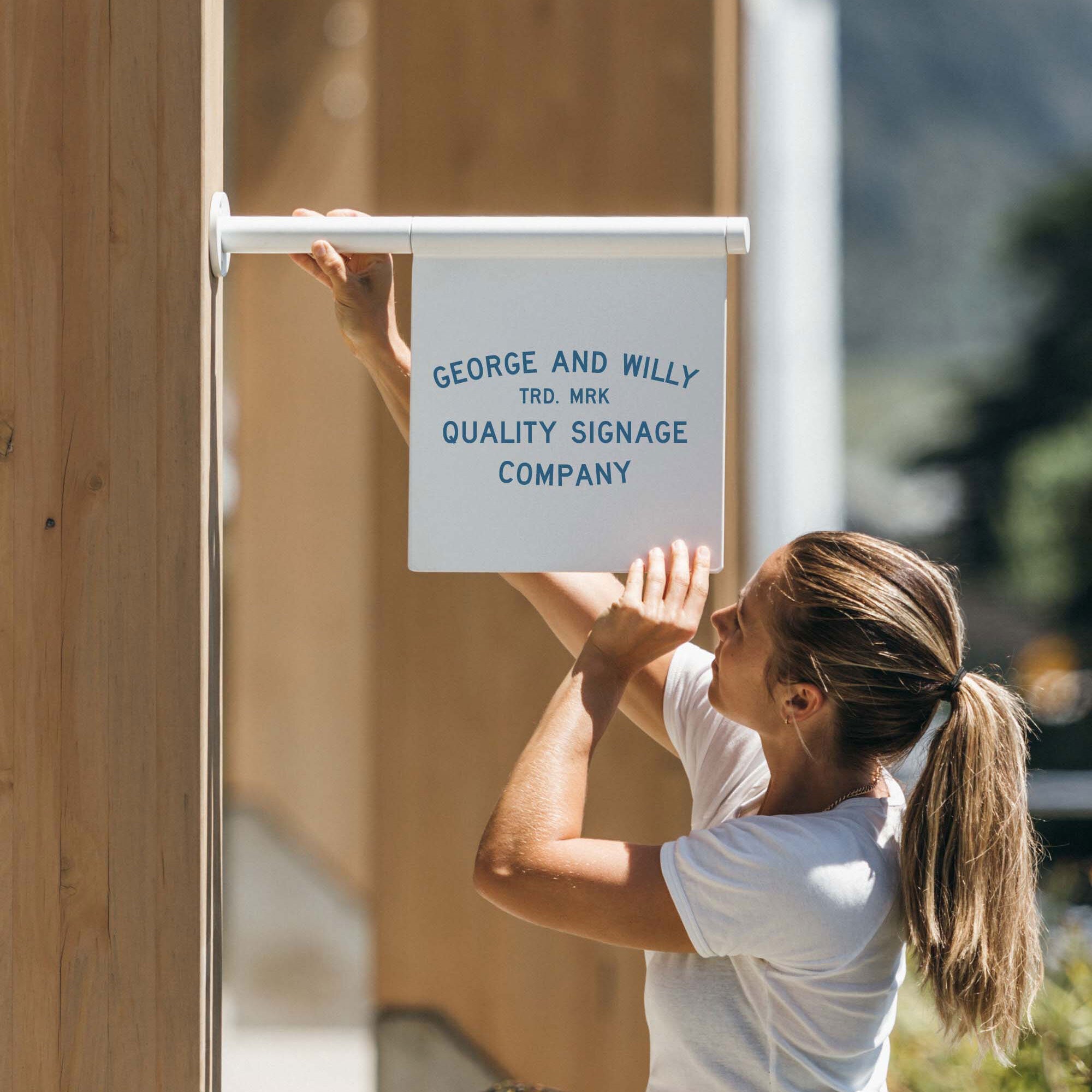 girl holding up the white flag business sign on a wooden beam